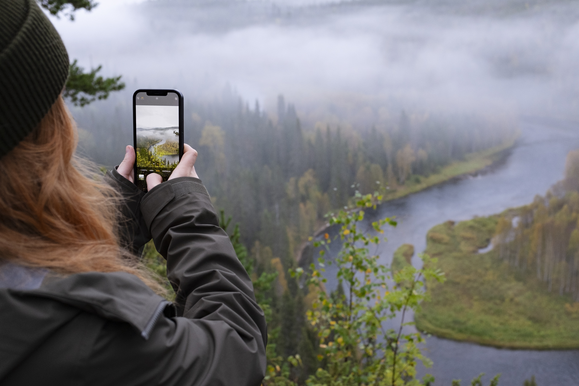 Kuvassa ihminen kuvaa puhelimella Oulankajokea